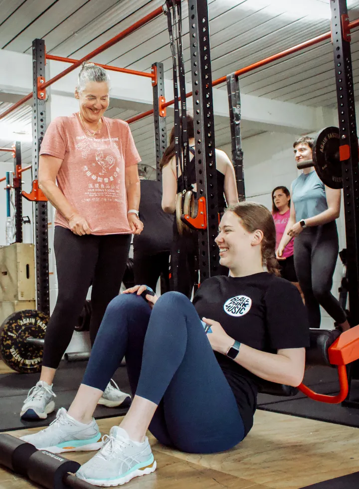 Smiling young women at an all-female Brisbane gym building strength, confidence, and gym skills in a supportive training environment.