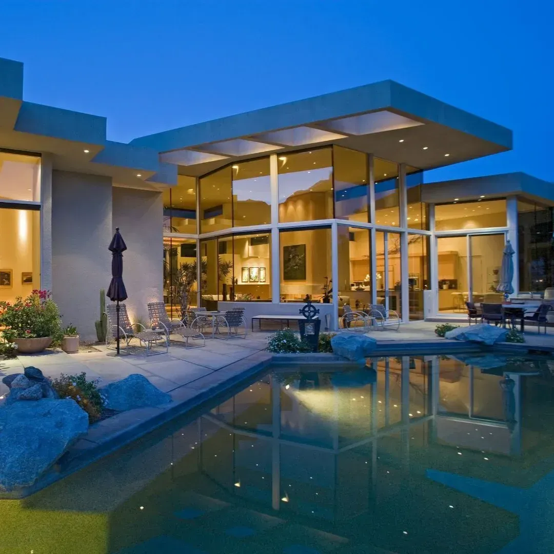 Modern home renovation in Flower Mound TX with large glass windows and outdoor pool