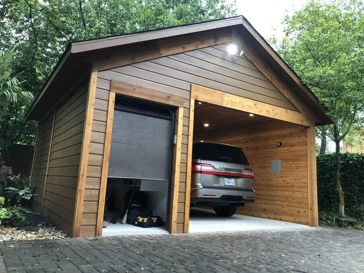 Custom detached garage with wood siding and overhead lighting in Addison, TX