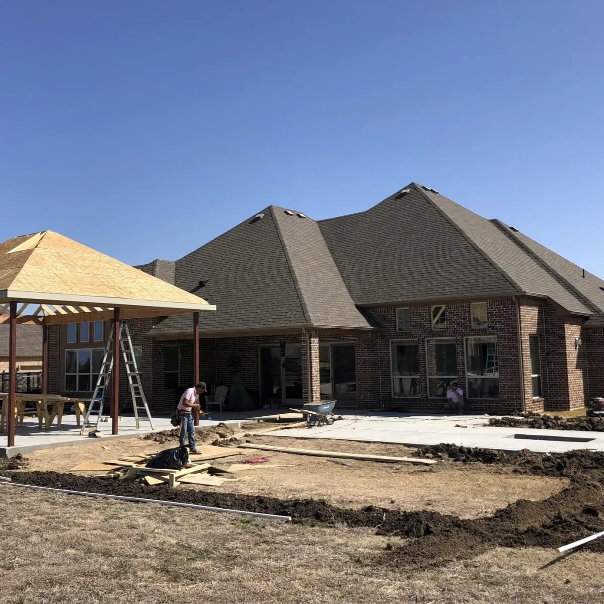 Full home remodel project in Carrollton, TX with patio cover construction and exterior home upgrades in progress.