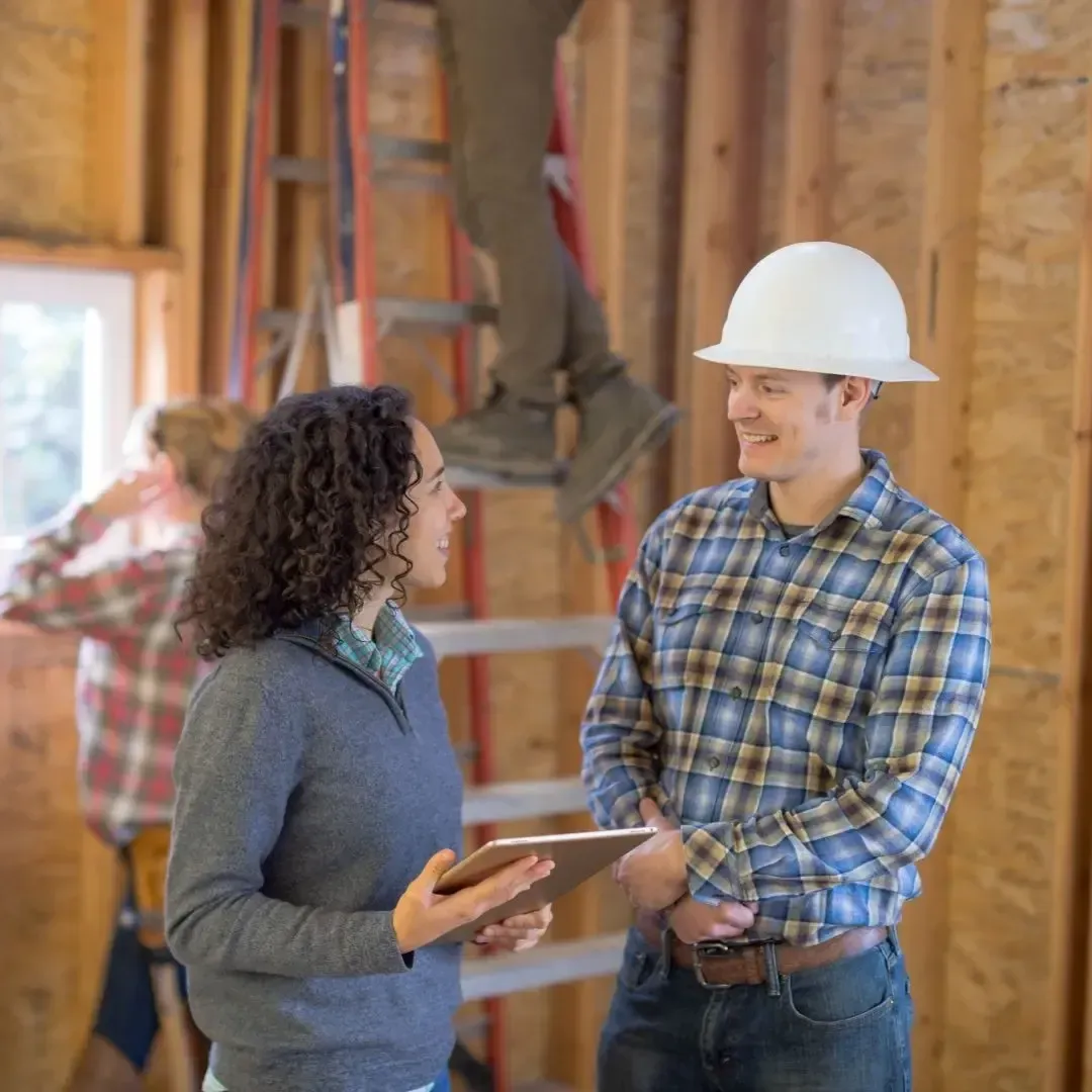 Home remodeling contractor in Sachse TX discussing project plans with a homeowner inside a house under renovation.