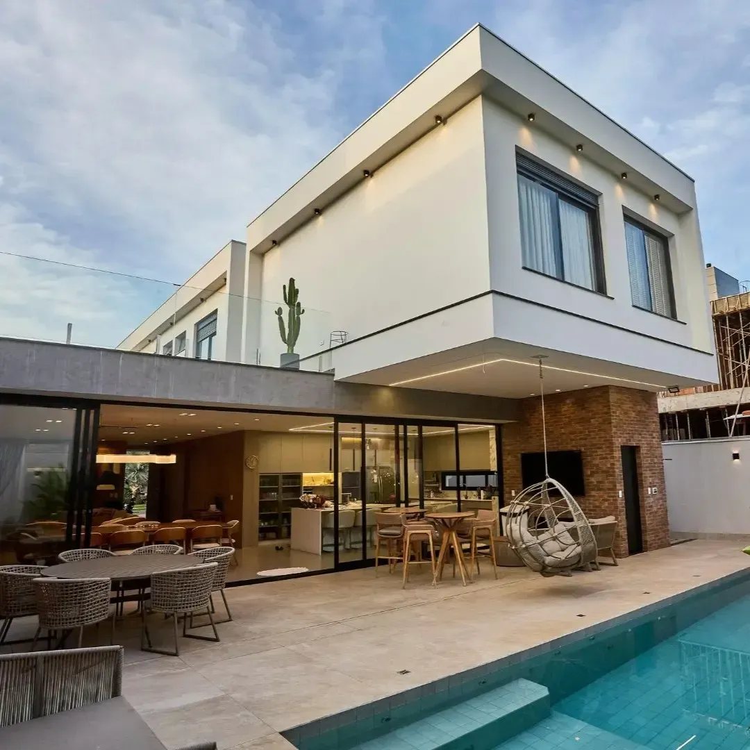Modern two story home addition in Wylie, TX with covered patio, outdoor dining area, and pool