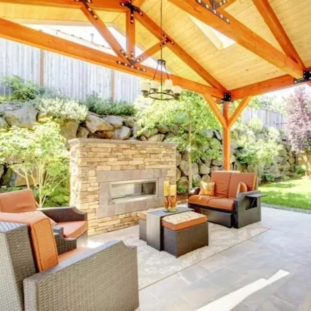 Exposed-truss backyard pavilion with stone fireplace and grill in Carrollton, TX