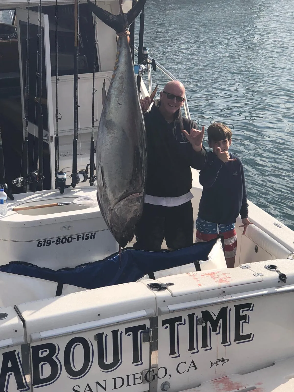 Divers ascend through sunlit ocean with fish.