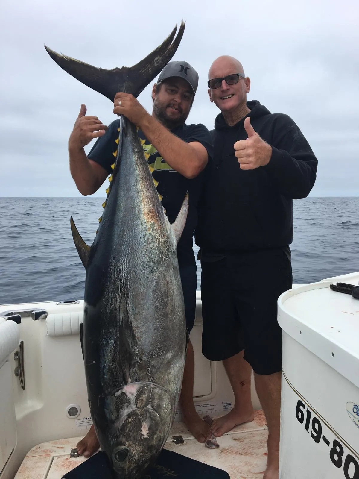 A small boat sails on a choppy, grey ocean.