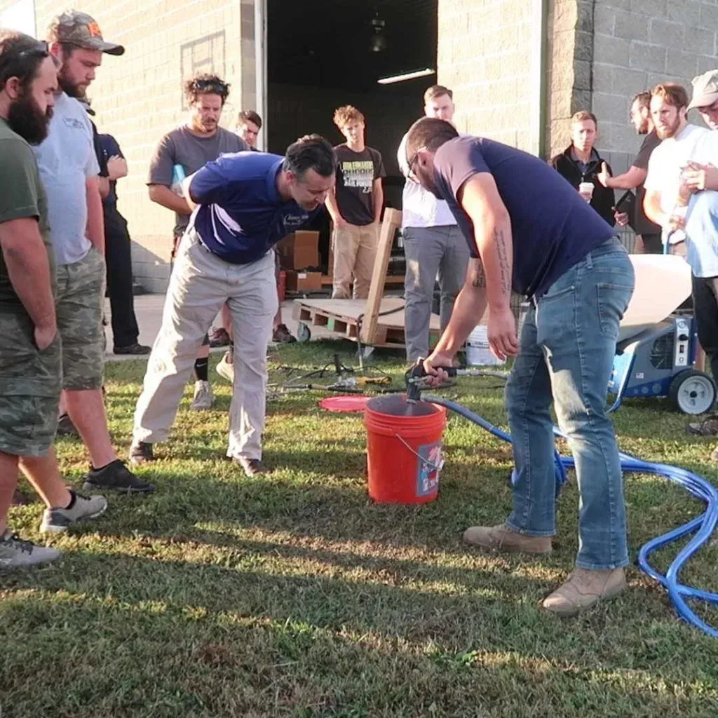 Cody demonstrates a new tool to the Chimney Works team. This sprayer is for parging smoke chambers.