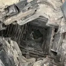 Cracked and rough smoke chamber in a Cincinnati chimney needing repair, showing gaps and unsealed surfaces that reduce draft and increase fire risk.