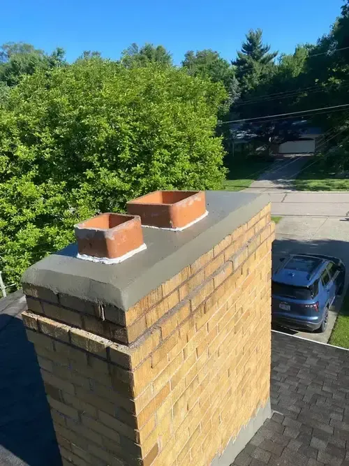 Newly repaired chimney crown on a Cincinnati home by ChimneyWorks, showing smooth, sealed concrete to protect against water damage and weathering.