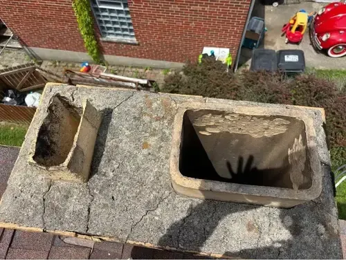 Damaged chimney crown on a Cincinnati chimney with visible cracks and crumbling edges, risking water infiltration and structural damage.