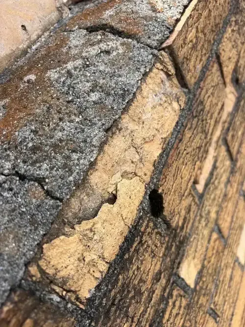 Crumbling bricks and deteriorated mortar on a Cincinnati chimney—visible signs of water damage leading to interior chimney leaks