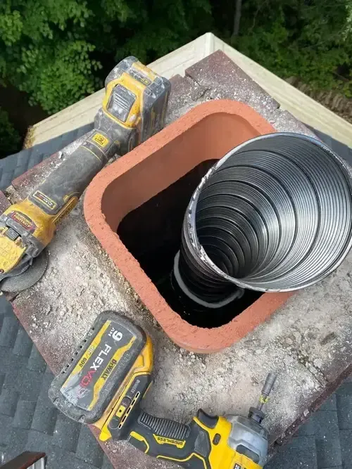 Top view of ChimneyWorks chimney liner installation in a Cincinnati home—liner visible exiting the flue for improved venting and code compliance.