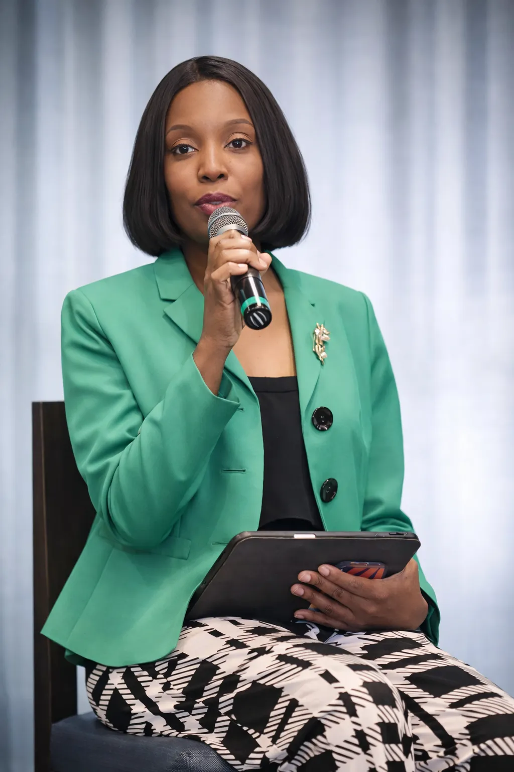two women in suits standing beside wall
