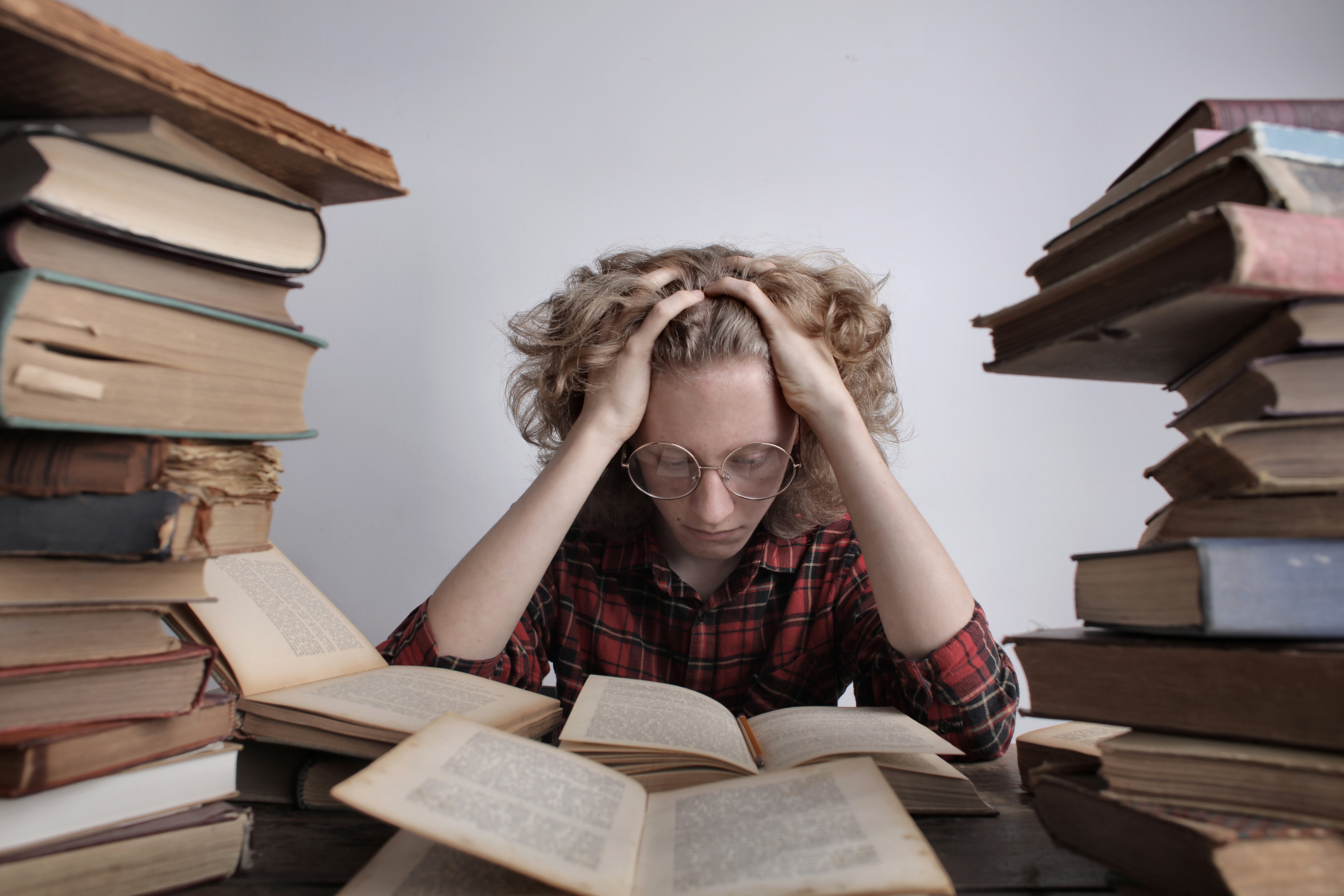 woman sitting surrounded by books feeling burned out by overachieving, somatic emdr