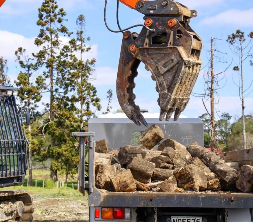 excavator grab loading logs Southland tree removal earthworks