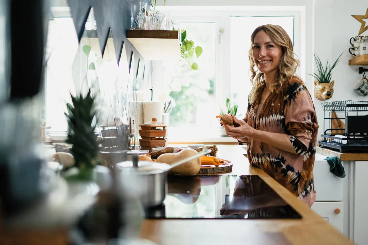 woman smiling while cooking