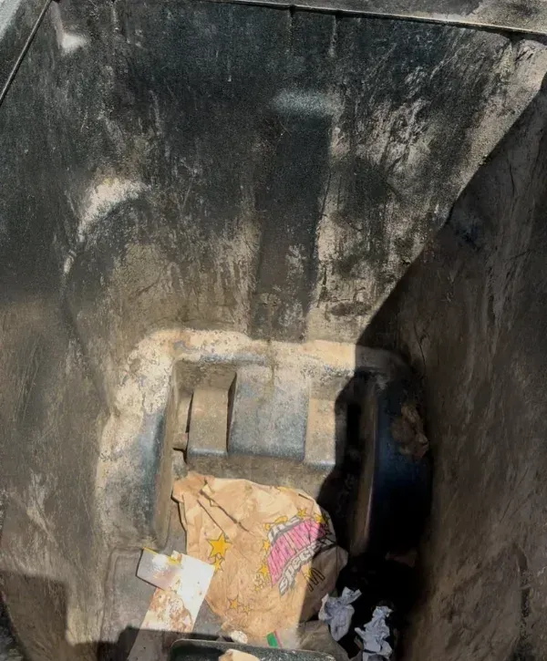 Dirty trash bin interior with food waste and debris before cleaning.