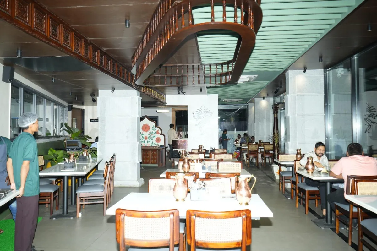 Fine-dine vegetarian restaurant interior at Crestfield Residency with table settings, natural light, and plant accents.