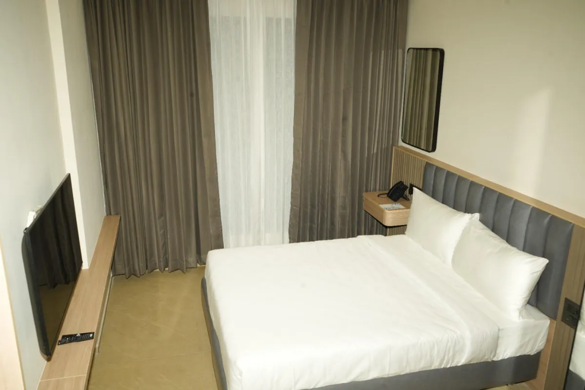 Standard Room with queen bed, workspace, and warm evening hotel lighting