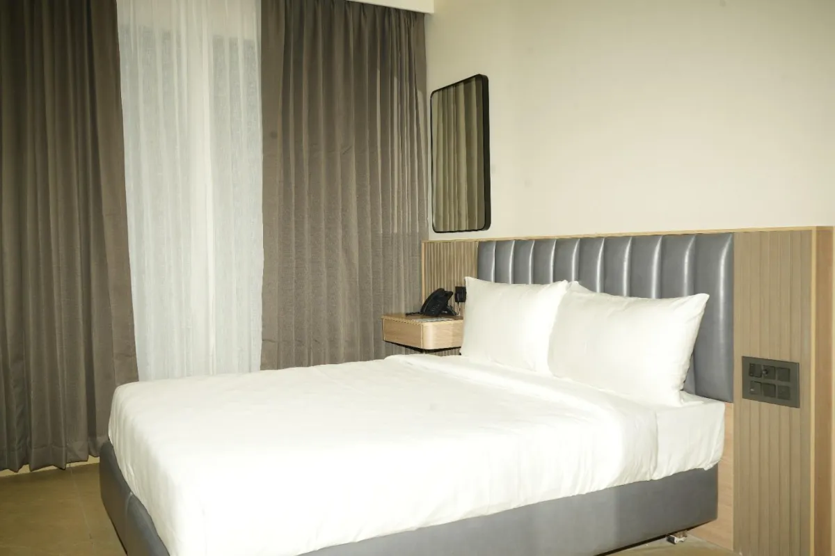 Standard Room with queen bed, workspace, and warm evening hotel lighting