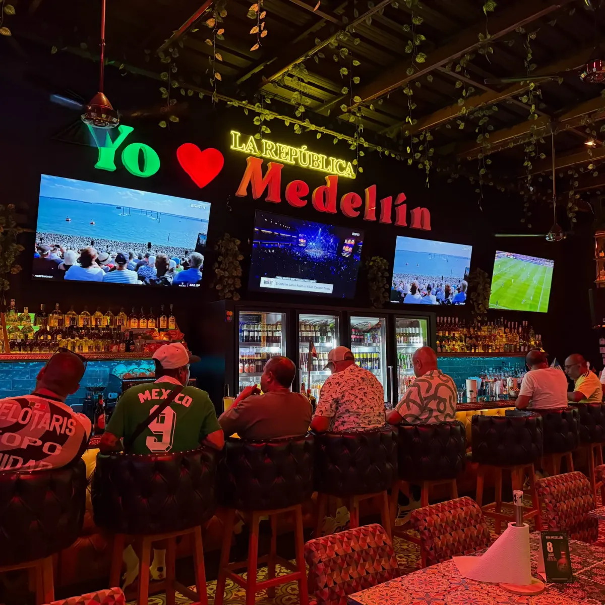 Guests watching live football on the screens above the bar at La República Sport Bar, El Poblado, Medellín