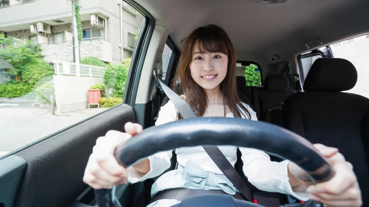 Driving instructor teaching a happy student driver