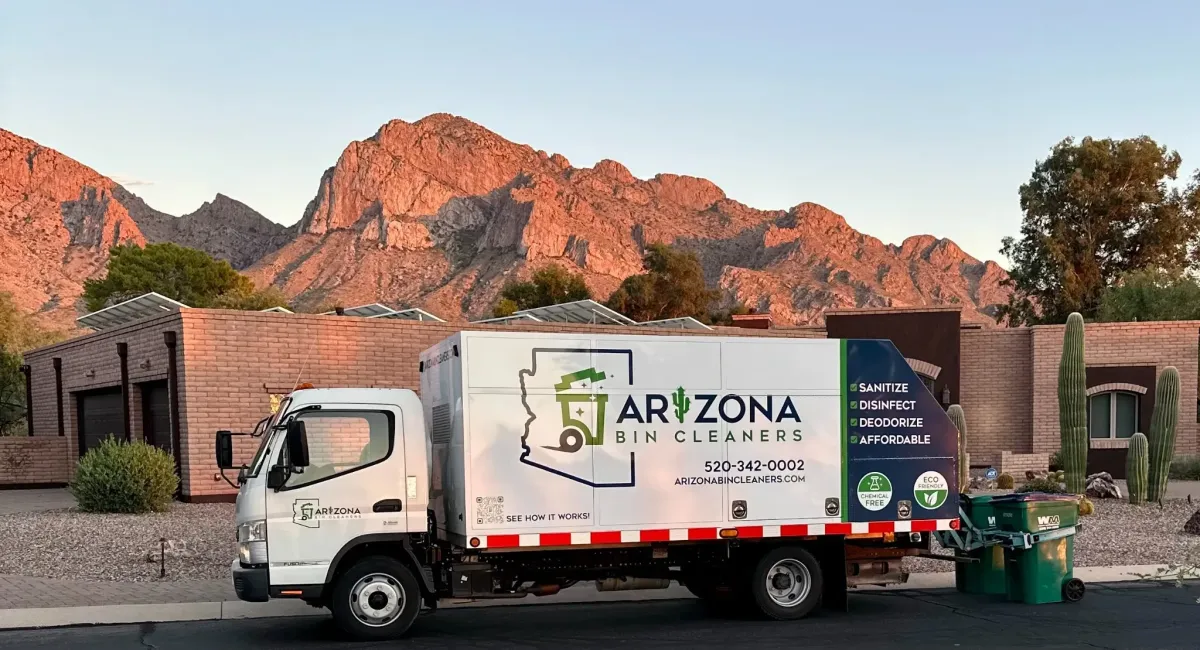 Arizona Bin Cleaners truck servicing trash bins in a Tucson neighborhood with mountains in the background