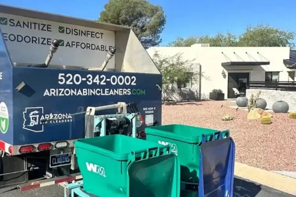 Rear view of bin cleaning truck with automated washing equipment and green waste carts.