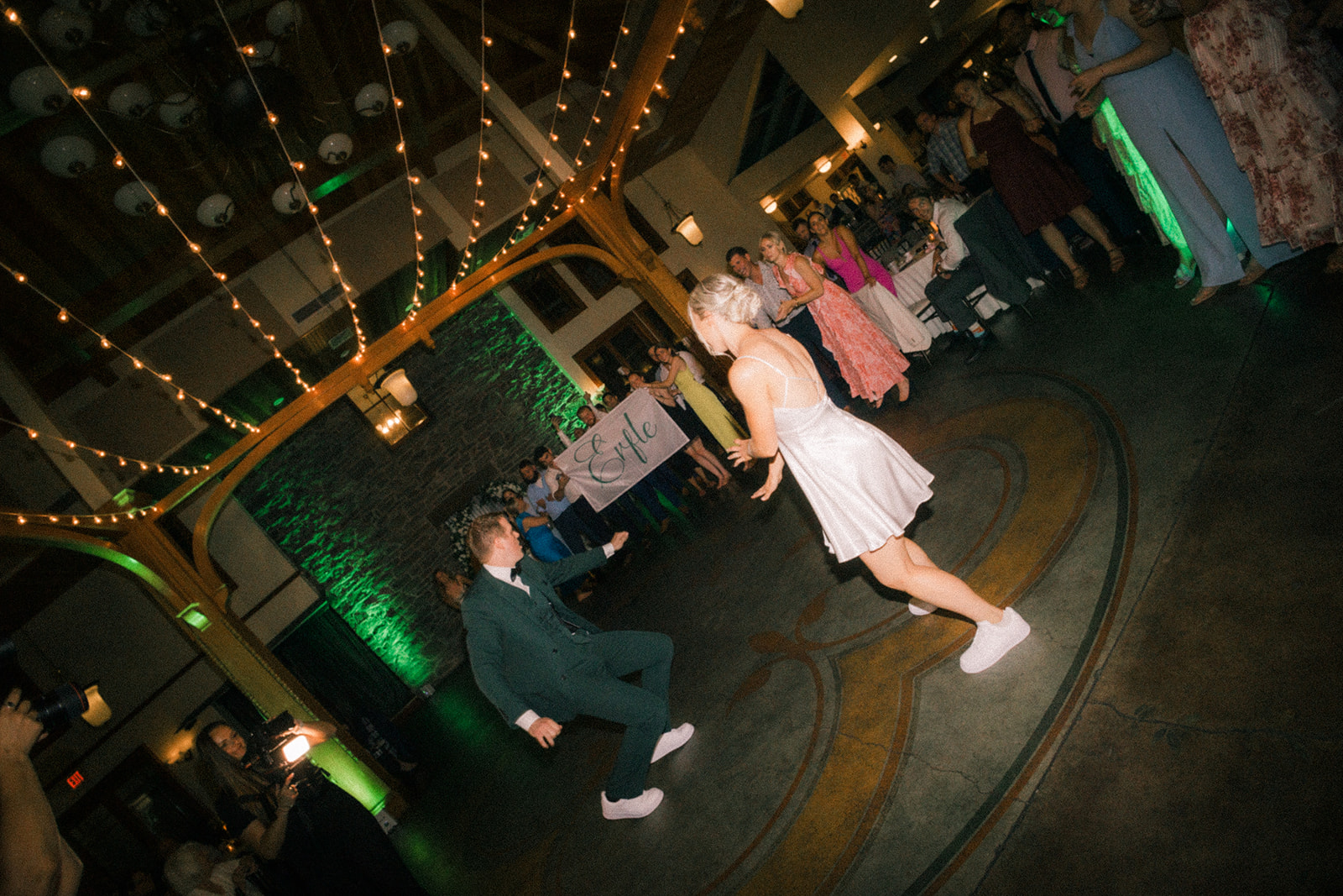 couple dancing on the dance floor celebrating with family and friends.