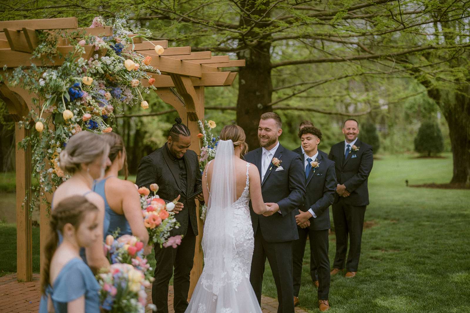 officiant reading ceremony while groom smiles at bride during wedding ceremony
