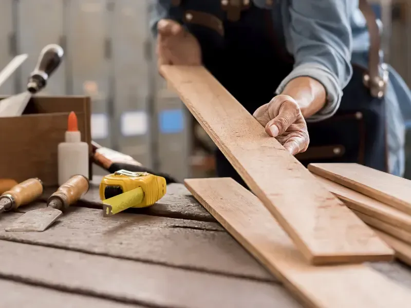 Deck builder selecting and inspecting wood boards.