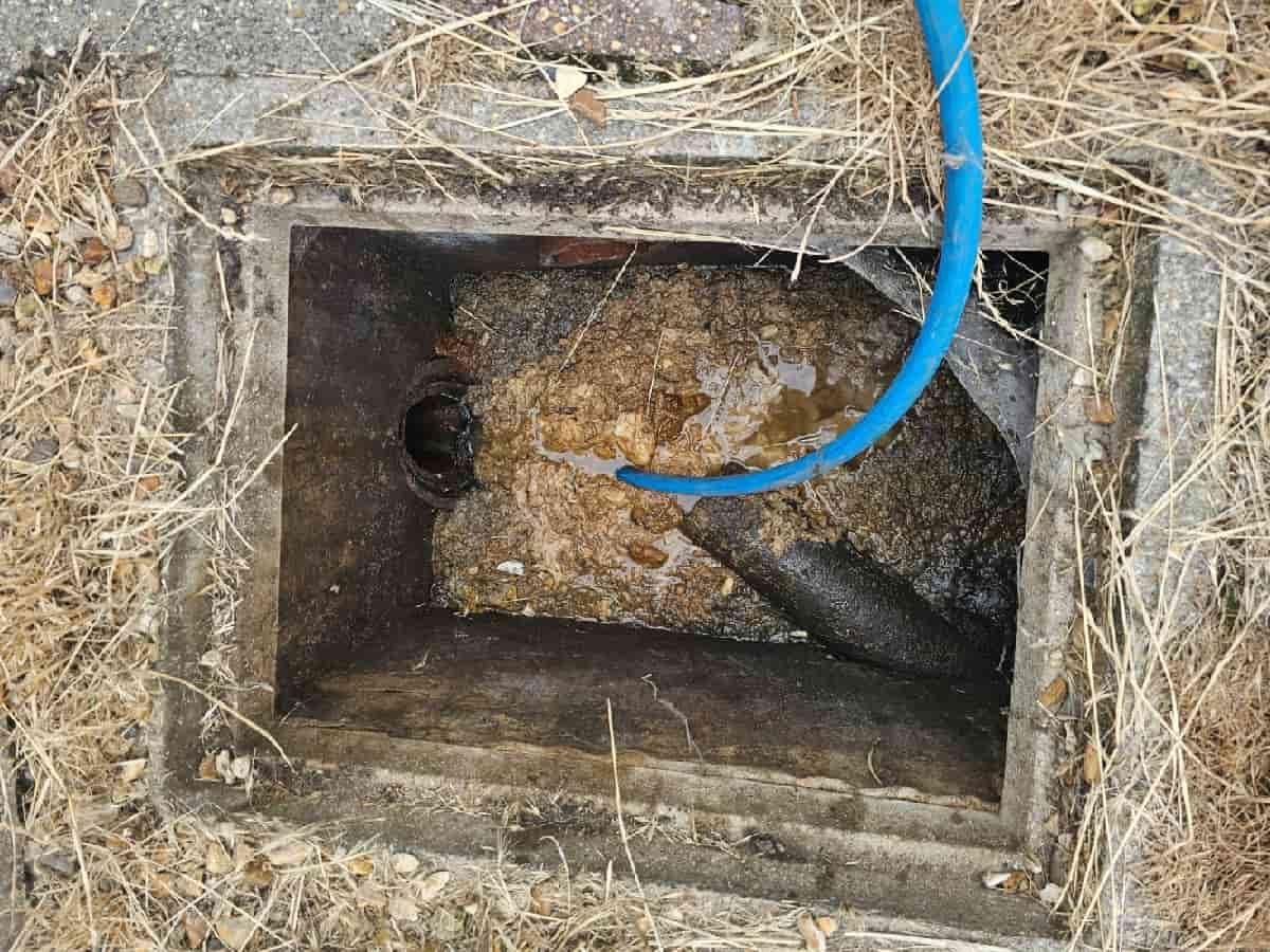 High-pressure water jetting equipment clearing a severely blocked manhole chamber in Bournemouth