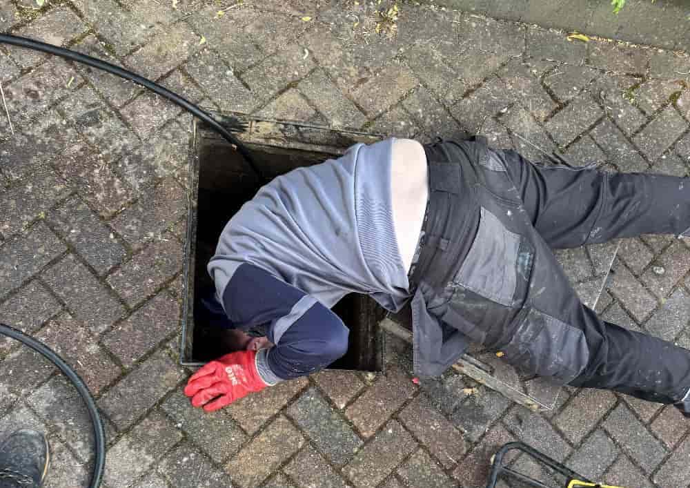 Drainage engineer carrying out manhole inspection in Bournemouth, demonstrating 1st Call Drainage's hands-on approach to drainage maintenance.