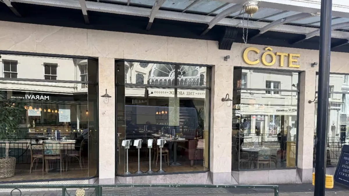 Côte restaurant storefront in Bournemouth showing the dining area through large glass windows with outdoor seating visible.