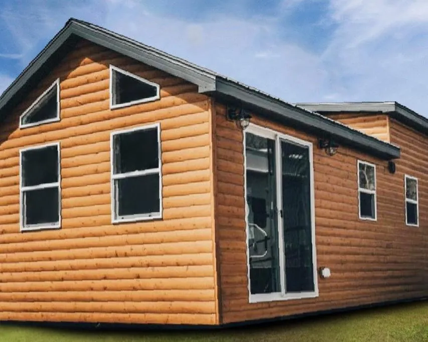 Tiny home exterior featuring a wooden facade, large windows, and a porch, representing the Trailblazer model by Snake River Tiny Homes.
