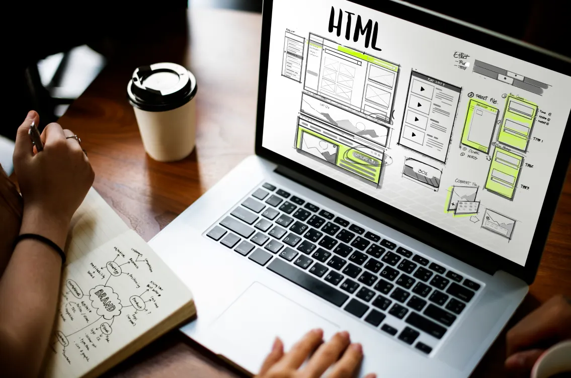 working html in laptop on a work desk with a side of coffee