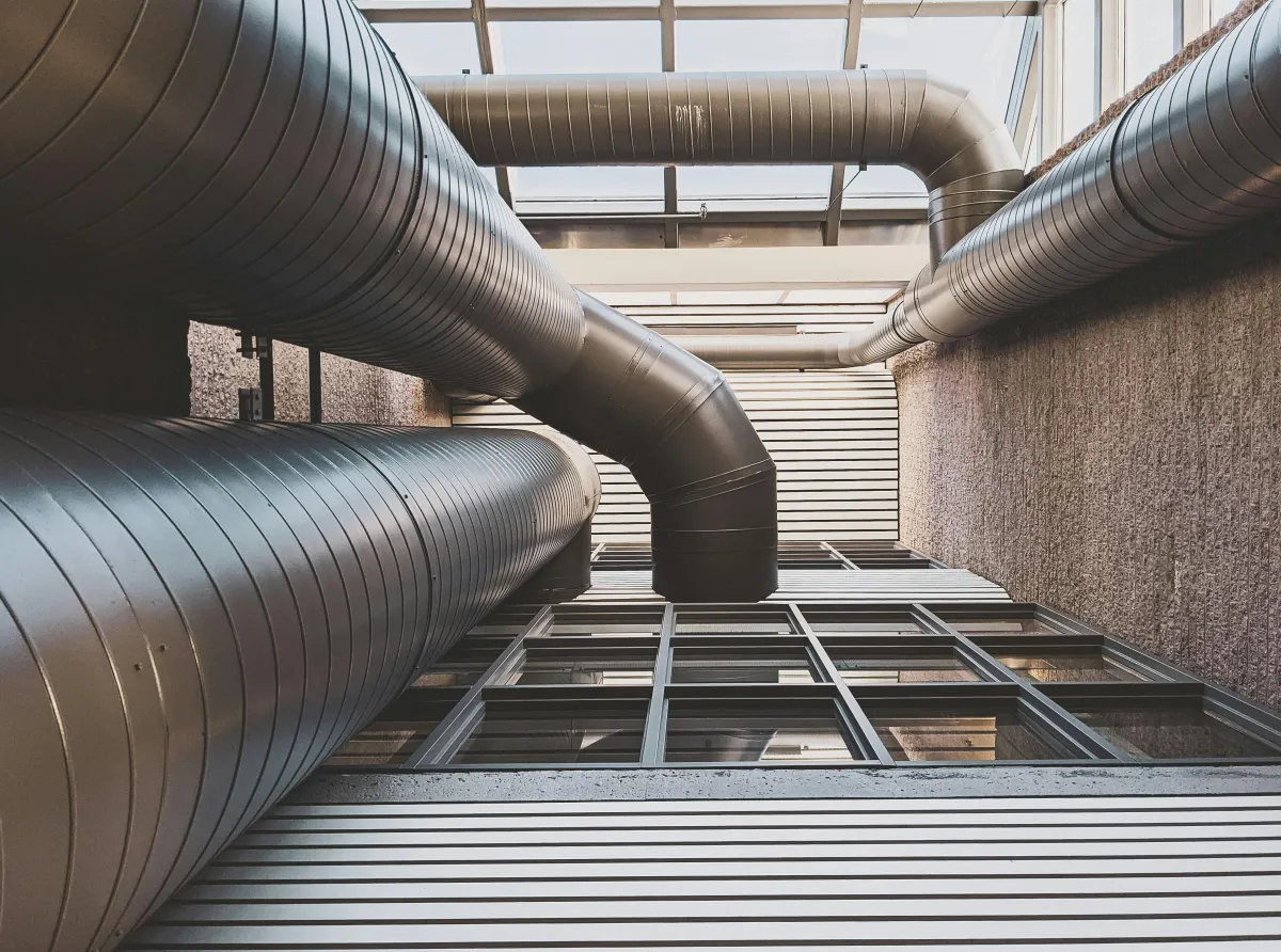 HVAC technician working with ductwork and mechanical equipment