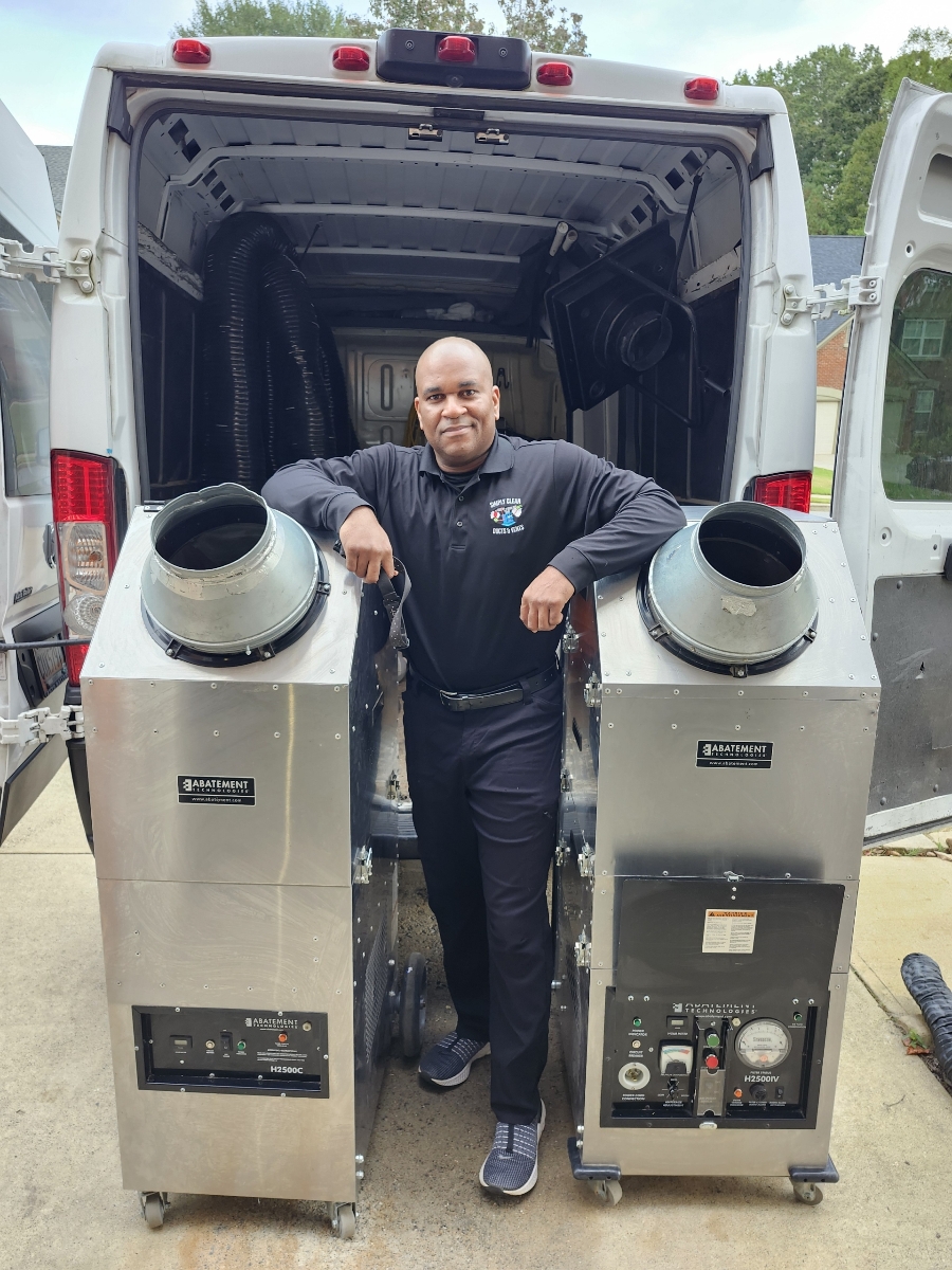 Simply Clean Ducts and Vents Owner Standing with HVAC equipment