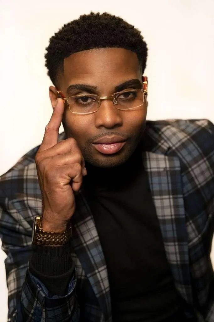 Man talking on phone with coffee and laptop.