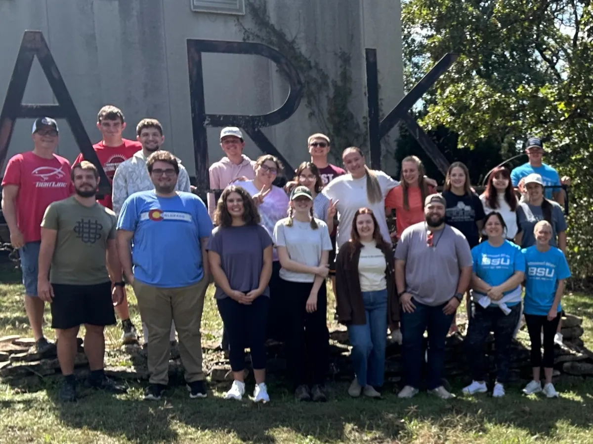People gathered at a blue rotary club outdoor event.