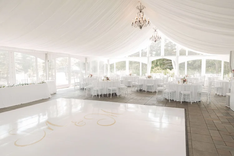 a table set for a formal dinner with white flowers and greenery
