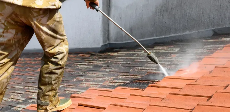 Technician pressure washing a commercial paver walkway