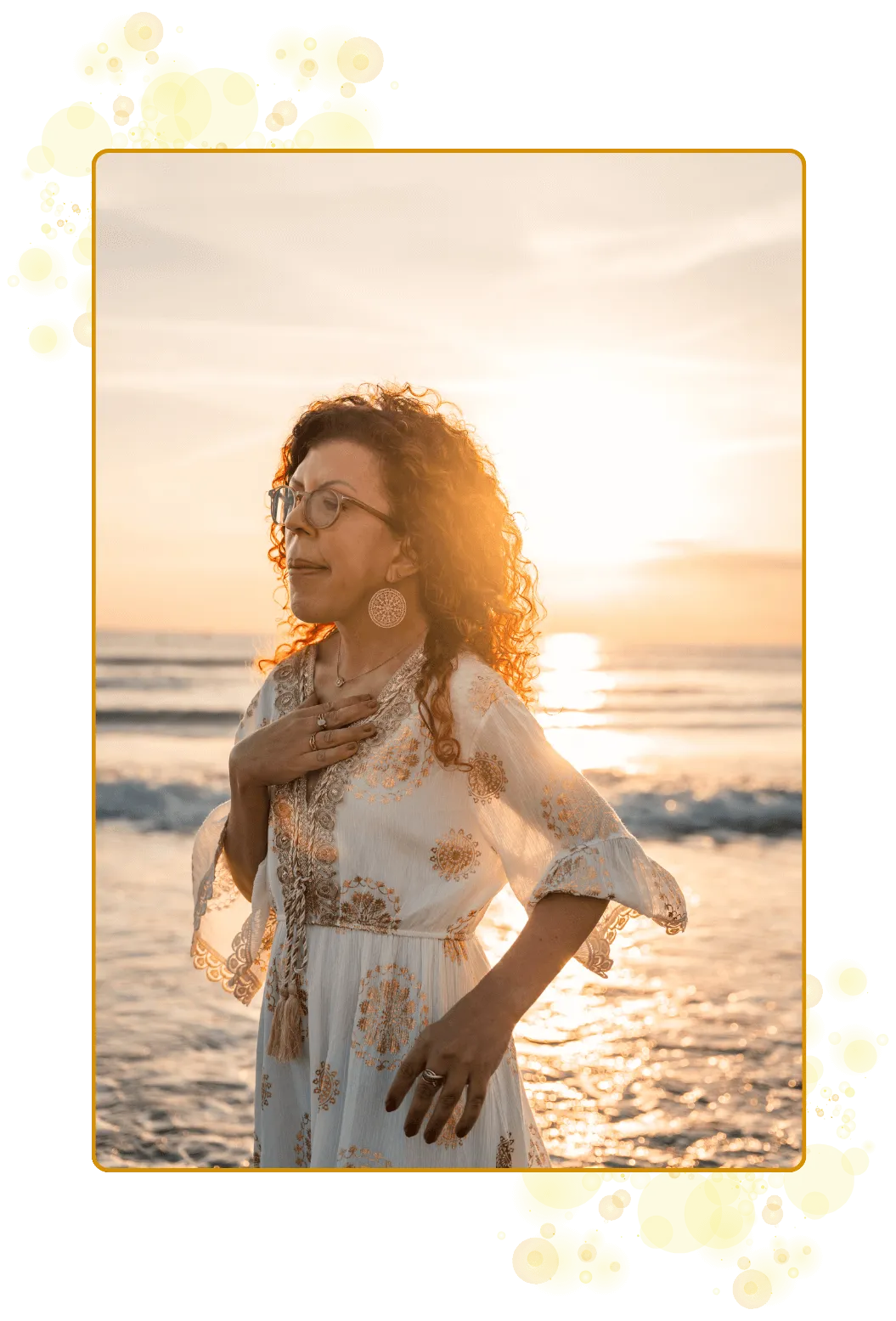 En kvinne med regnbuelys over brystet og med hånden på hjertet. Lykkelig tilstede og nærværede. I sin kraft. I sin sannhet I sitt lys. I sin autentisitet.