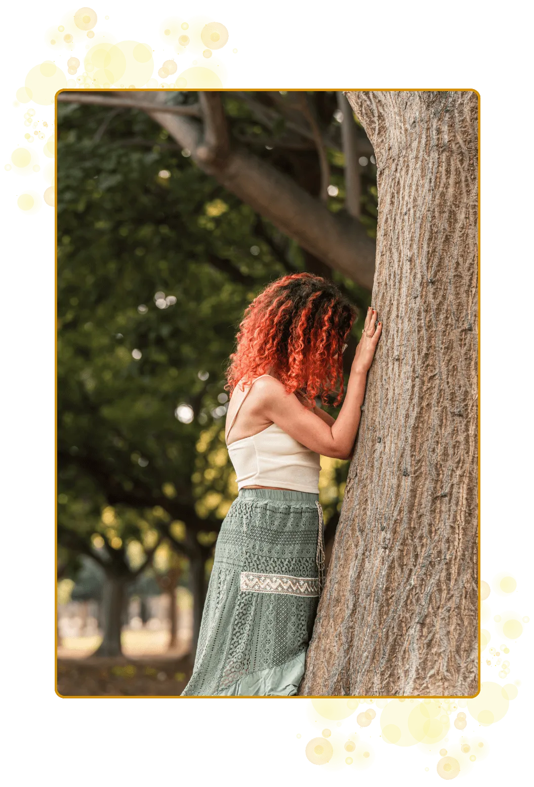 Kvinne med knall rødt hår og krøller mottar i takknemlighet, og med åpent hjertechakra, den magiske energien og kraften fa et tre.