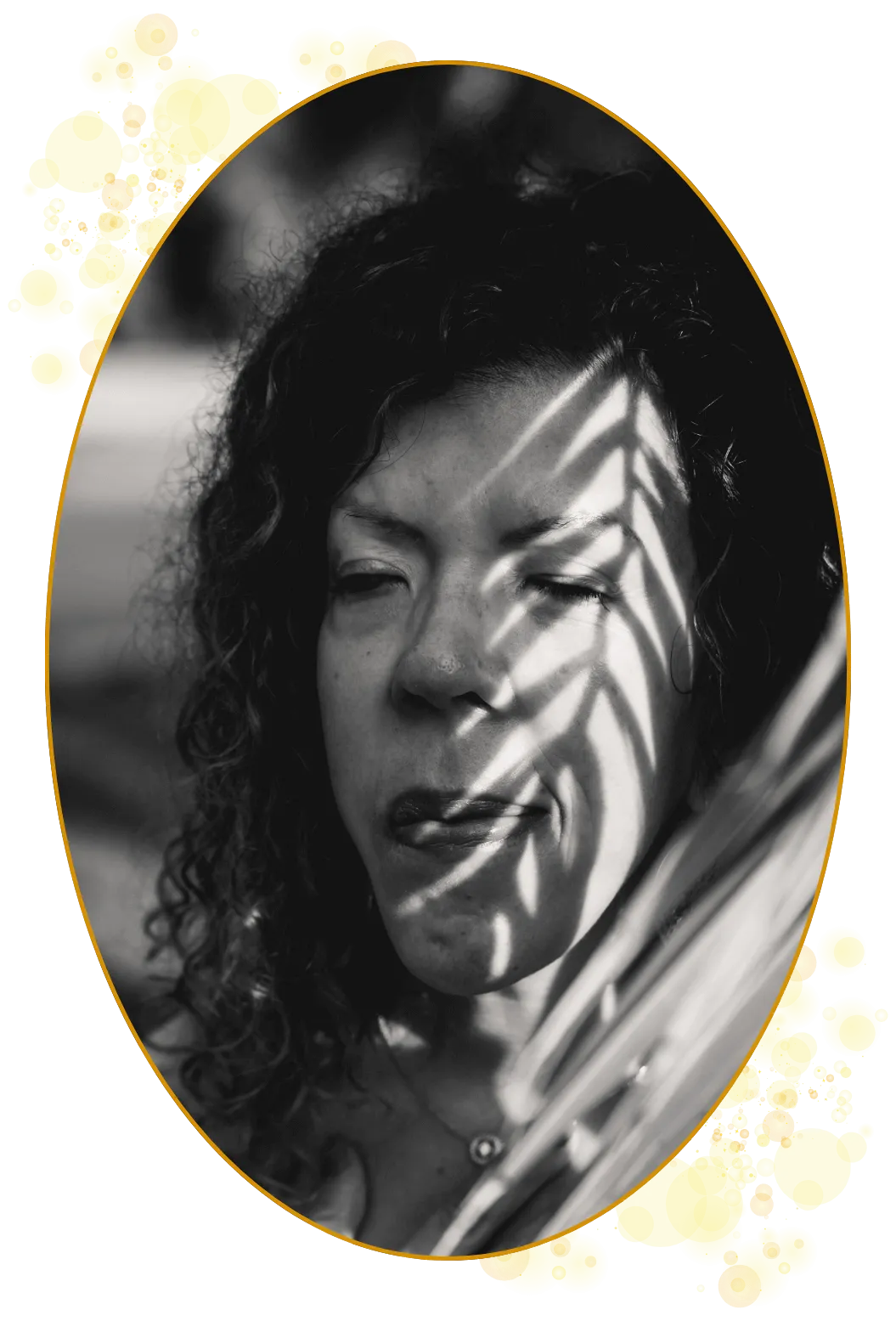 Litt kunstnerisk bilde i svart/hvitt og med lys og skygger i ansiktet – skygger fa et palmeblad.