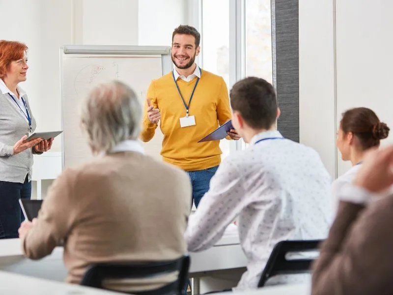 man and woman training a team of teachers