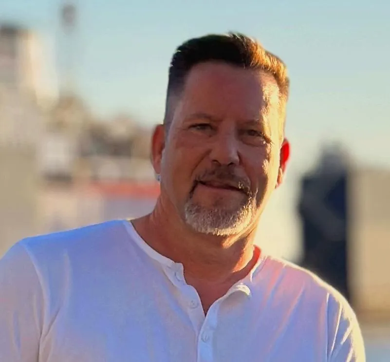 "Dennis Lee, cybersecurity expert and digital educator, smiling in a professional headshot"