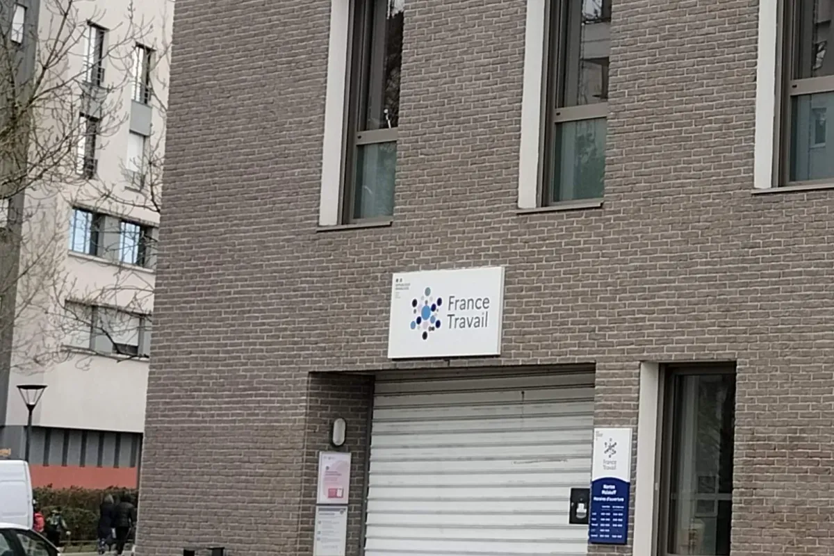 Enseigne France Travail sur la façade en brique de l'agence de Nantes Malakoff, au-dessus du rideau métallique de l'entrée