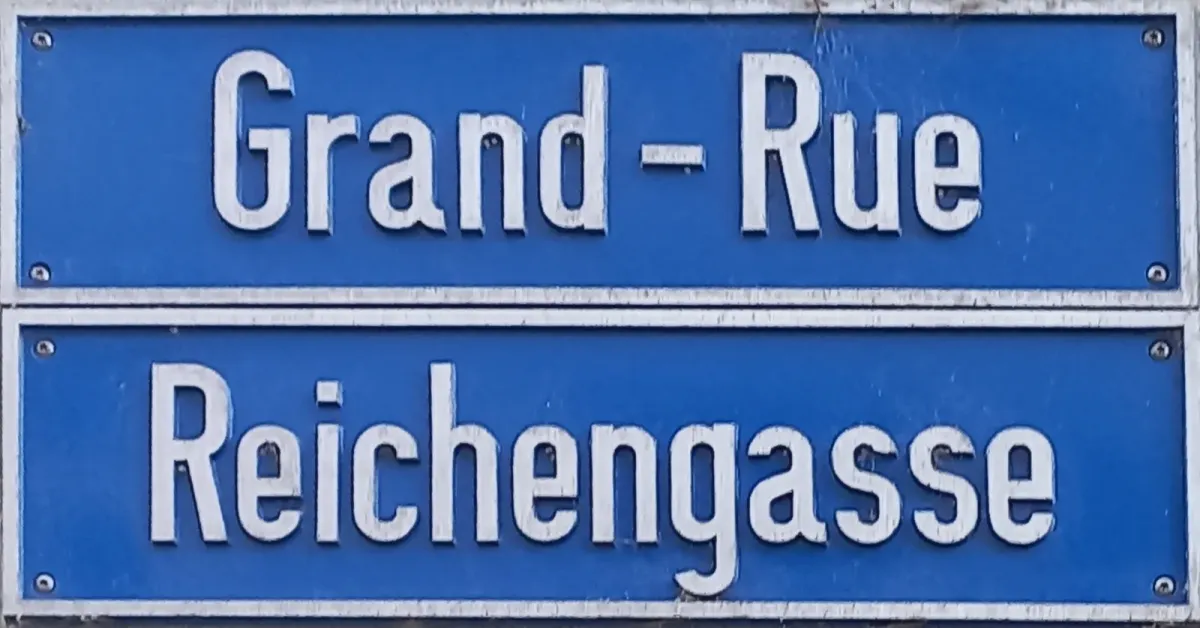Deux plaques de rue bleues superposées, Grand-Rue en français au-dessus de Reichengasse en allemand