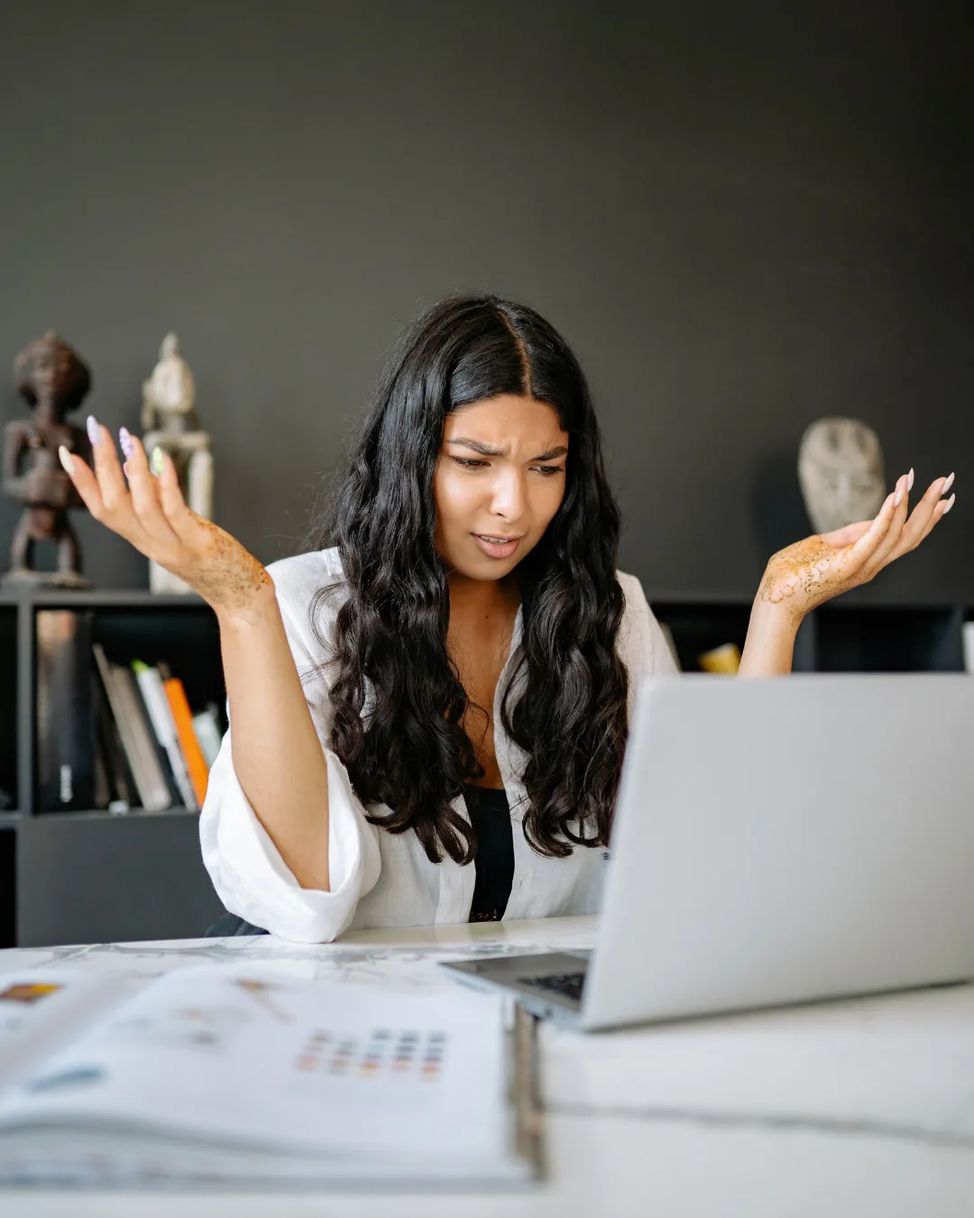 Woman seems baffled about money while staring at her computer