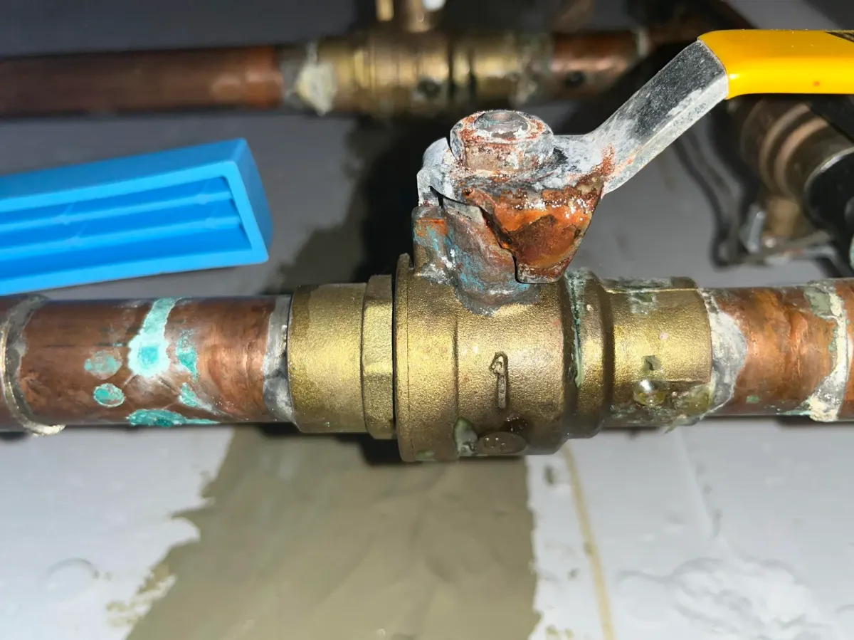 Heavily rusted shut-off valve with buildup, highlighting flood risk if not replaced.